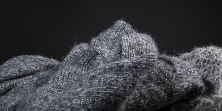 crumpled gray handmade cashmere wool fabric texture on a black background.の写真素材