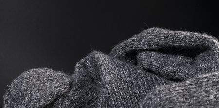 perspective view of a close-up handmade cashmere gray wool fabric texture on a dark background.の写真素材