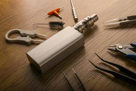 tools for vaping device, electronic cigarette, e-cigarette, box mod, accessories isolated over a wooden background. for vaping shops.の写真素材
