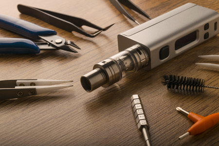 tools for vaping device, electronic cigarette, e-cigarette, box mod, accessories isolated over a wooden background. for vaping shops.の写真素材