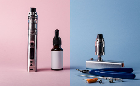 Isolated modern electronic cigarette with e liquid bottle and accessories for vape devices. creative e cigarette background. の写真素材