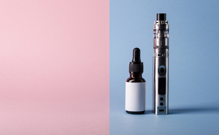 Isolated modern electronic cigarette with e liquid or e juice bottle for vape devices. creative e cigarette background. の写真素材