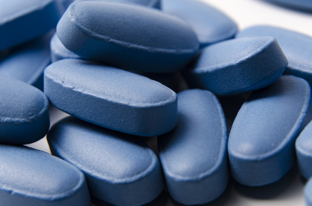 close up of blue pills or tablets over a white background. の写真素材
