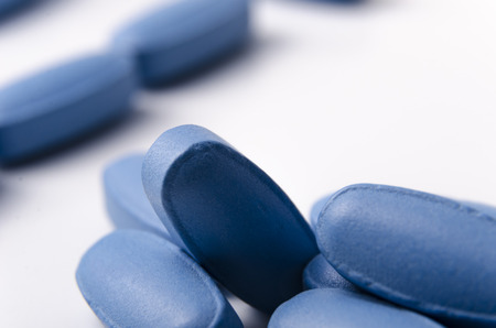 close up of blue pills or tablets over a white background. の写真素材