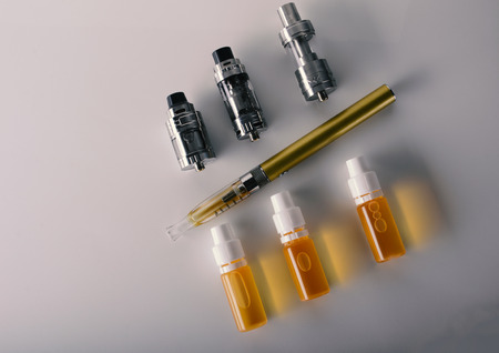 isolated vape tanks and e liquid for electronic cigarette or e cig over a white background. vaping rdta and e juice for vaping devices. の写真素材