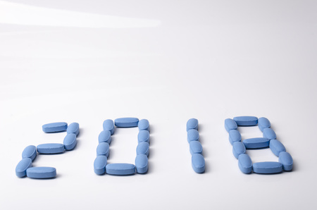 Creative 2018 new year concept made out blue medical tablets over a white background. の写真素材