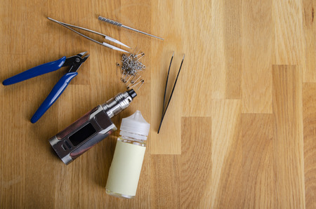 : Popular vaping e cig devices mod.electronic cigarette over a wood background. vaporizer e-cig old device model.の写真素材