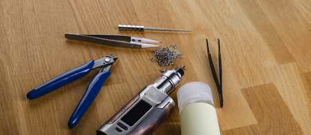 : Popular vaping e cig devices mod.electronic cigarette over a wood background. vaporizer e-cig old device model.の写真素材