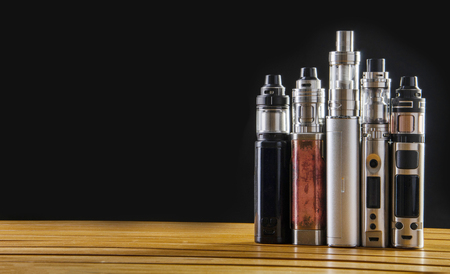 Popular vaping e cig devices mod.electronic cigarette over a black background. vaporizer e-cig old device model. pen cigaretteの写真素材