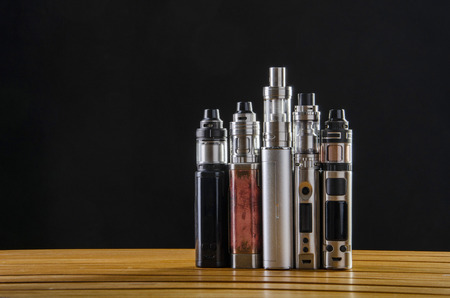 Popular vaping e cig devices mod.electronic cigarette over a black background. vaporizer e-cig old device model. pen cigaretteの写真素材