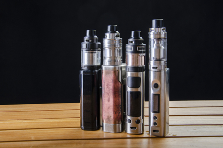 Popular vaping e cig devices mod.electronic cigarette over a black background. vaporizer e-cig old device model. pen cigaretteの写真素材