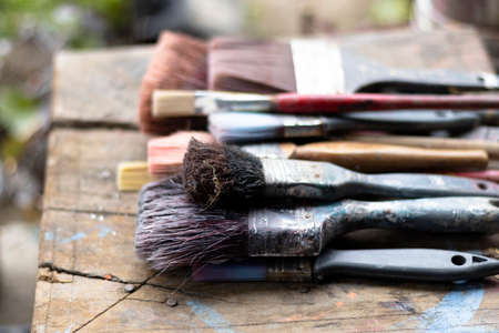 Closeup of used paint brushes of various sizes and typesの写真素材