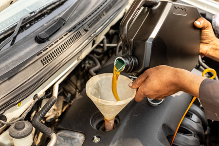 Mechanic pouring motor oil into the car engineの写真素材