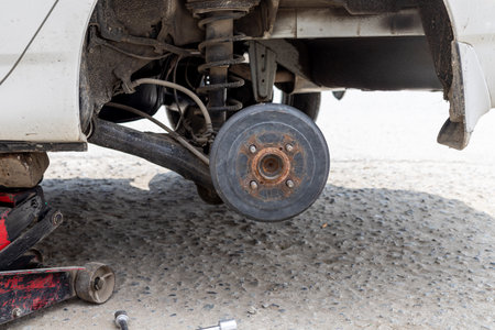 Rear wheel removed, and car is been lifted by hydraulic jack for repairの写真素材