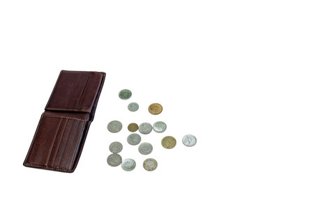 Brown leather wallet with scattered coins on a white backgroundの写真素材