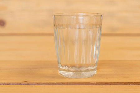 Glass of water on a wooden table. Selective focus.の写真素材