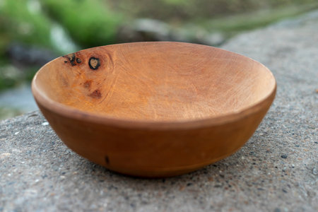 Empty wooden bowl closeup with blurred backgroundの写真素材