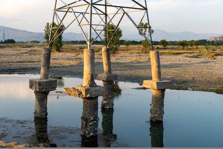 Electric power tower base soil is gone after heavy flood in the riverの写真素材