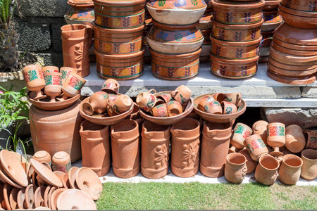 Stacks of various clay pots and earthenware in a shopの写真素材