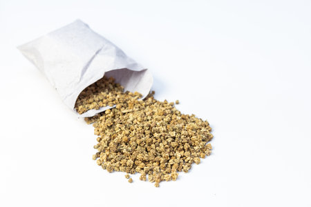 Green spinach seeds in a white paper pack on white backgroundの写真素材
