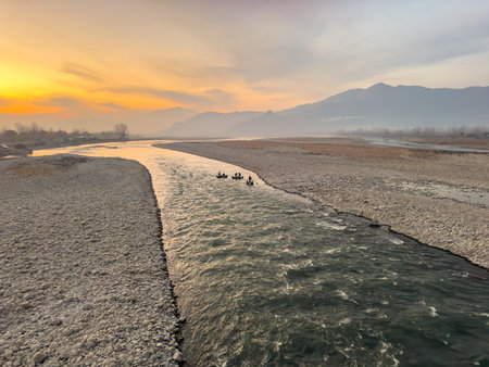 Beautiful landscape view of a fishermen sailing in an inflatable boat made from a car's tire tubes in the river Swat at dusk.の写真素材