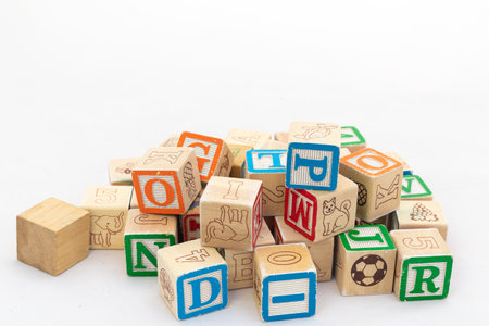 Wooden cubes with alphabets scattered isolated on white backgroundの写真素材