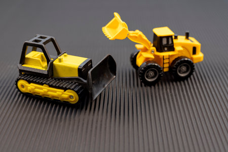Yellow Construction Toy Vehicles on Black Backgroundの写真素材