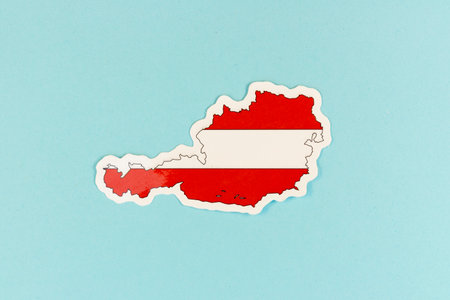 Austria Flag Sticker in Country Shape on Blue Backgroundの写真素材