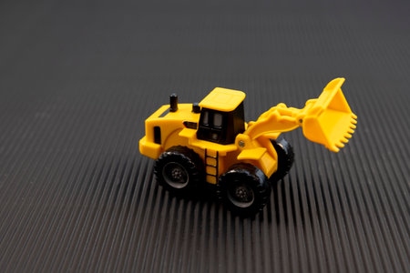 Yellow Toy Loader on Black Textured Background. Heavy machinery concept.の写真素材