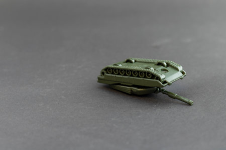 Toy military tank model laying upside down on a dark backgroundの写真素材