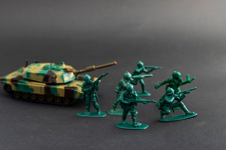 Green toy soldiers with camouflage tank on black backgroundの写真素材