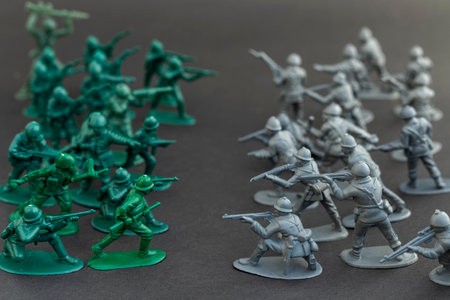 Two different countries plastic toy soldiers, green one gray are standing ready with rifles to fight. War concept.の写真素材