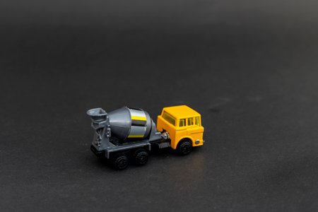 Yellow cement mixer toy truck on black backgroundの写真素材