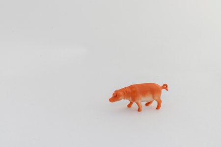 Miniature plastic pig toy isolated on white backgroundの写真素材