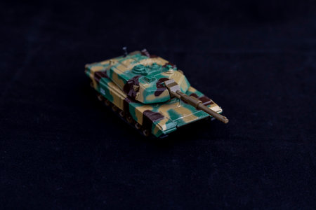 Green and brown camouflage tank model on dark backgroundの写真素材