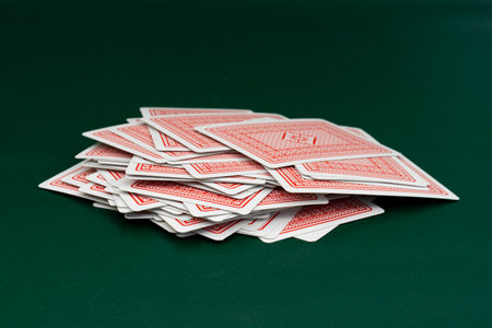 Red back playing cards deck spread on green tableの写真素材