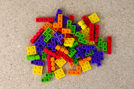Pile of Colorful Interlocking Toy Blocks on Wooden Surfaceの写真素材
