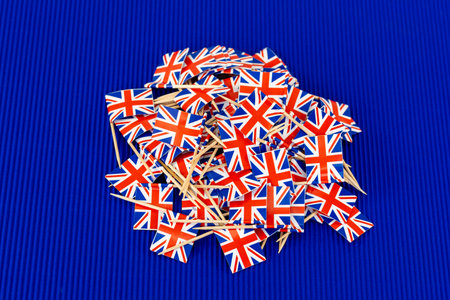 A pile of United Kingdom Union Jack flags on blue backgroundの写真素材