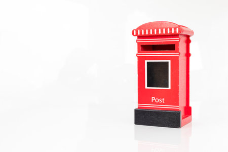 Miniature Red Vintage Post Mailbox Toy on White Backgroundの写真素材