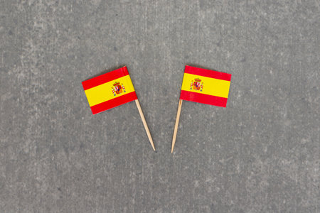 Two Small Spain Flags on Grey Backgroundの写真素材