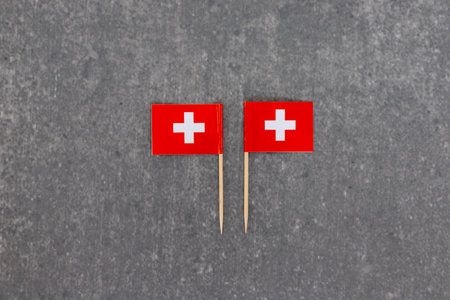 Dual Swiss Flags on Toothpicks on Grey Background. Symmetry Display.の写真素材