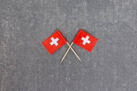 Crossed Switzerland Flags on Gray Backgroundの写真素材