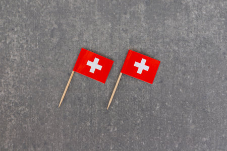 Tilted Pair of Switzerland Flags on Gray Backgroundの写真素材