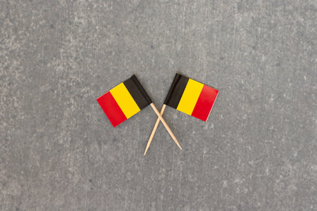 Two Belgium Flags Crossed on Gray Backgroundの写真素材
