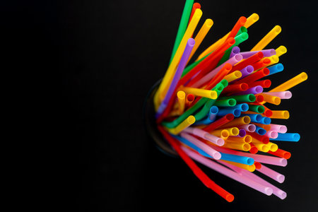 Overhead View of a Black Mesh Holder Filled with Colorful Drinking Straws.の写真素材