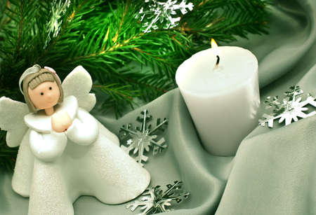 Christmas composition: Angel, a candle and a fir branchの写真素材