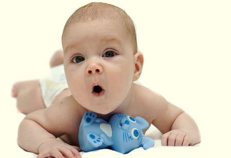 The amusing kid lies on a stomach and yawnsの写真素材