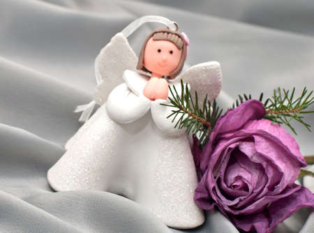 Christmas composition: Angel, a rose and a fir branchの写真素材