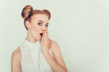 Close-up portrait of surprised beautiful girl with funny hairstyle.  Sly and scheming young woman face expression.の写真素材