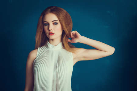 Close-up portrait beautiful girl on a blue backgroundの写真素材